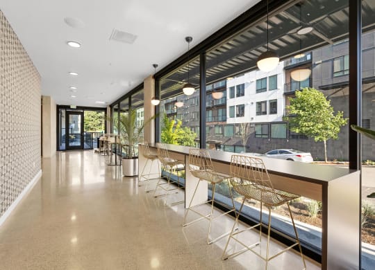 a long corridor with a long counter and a row of chairs in front of a large window at Ion Town Center, Shoreline Washington