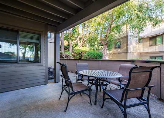 A patio with a table and chairs.