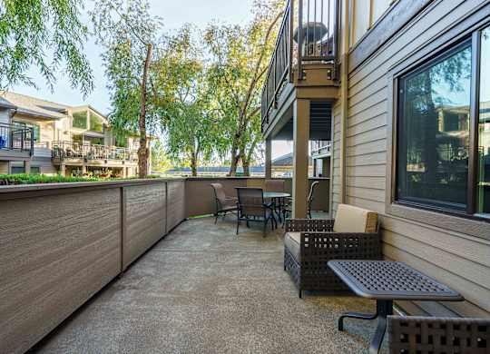 A patio with a table and chairs overlooks a body of water.