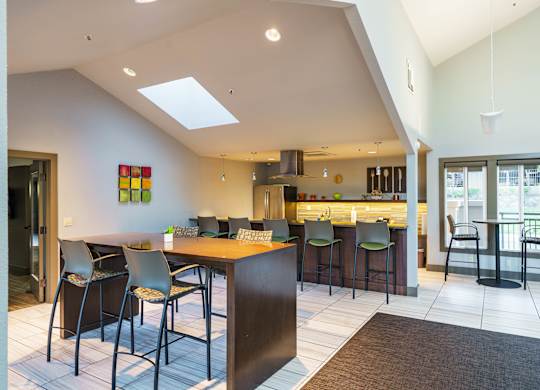A modern kitchen with a bar area and a dining table.
