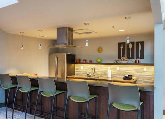 A kitchen with a bar area and four chairs.