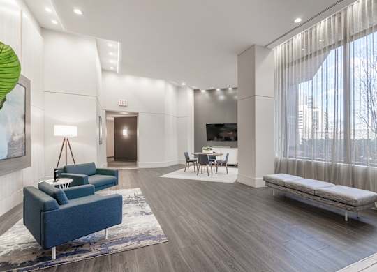 a living room with white walls and a large window and a couch
