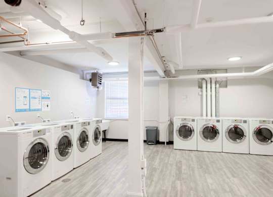 A row of washing machines in a laundry room.