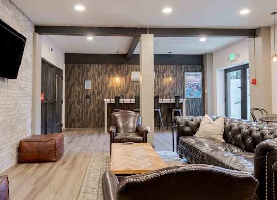 A living room with a leather couch and a wooden table.