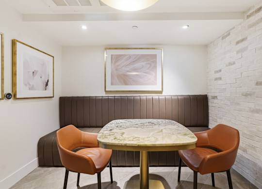 A dining room with a round table and four chairs.