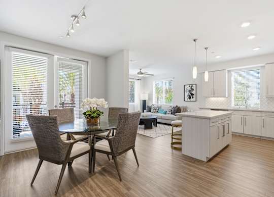 A modern dining room with a glass table and chairs.