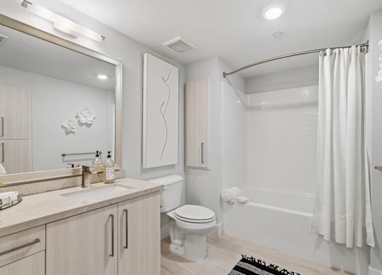 A white bathroom with a toilet, sink, and bathtub.