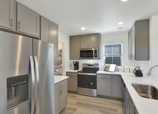 a kitchen with stainless steel appliances and white counter tops