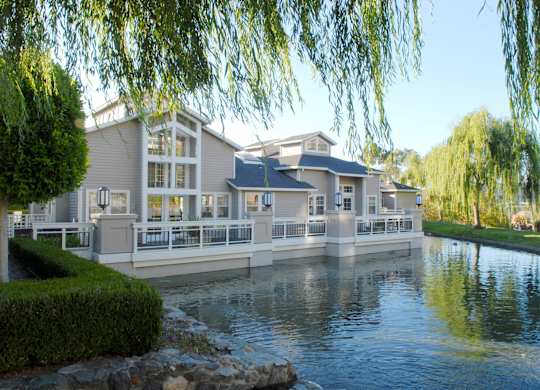 a large house sitting on the water next to a lake