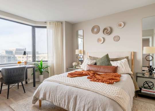 A bedroom with a large bed and a view of the city.