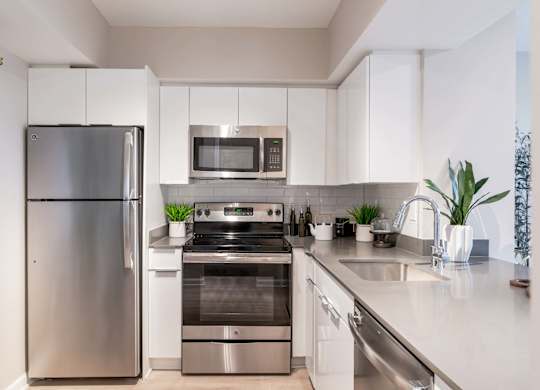 A modern kitchen with stainless steel appliances and white cabinets.