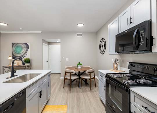 A modern kitchen with a table and chairs in the middle at Clear Creek Meadows Apartments, Copperas Cove, 76522