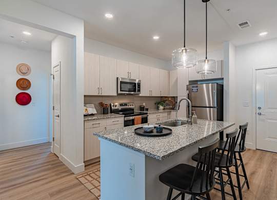 A kitchen with a granite countertop and a refrigerator.