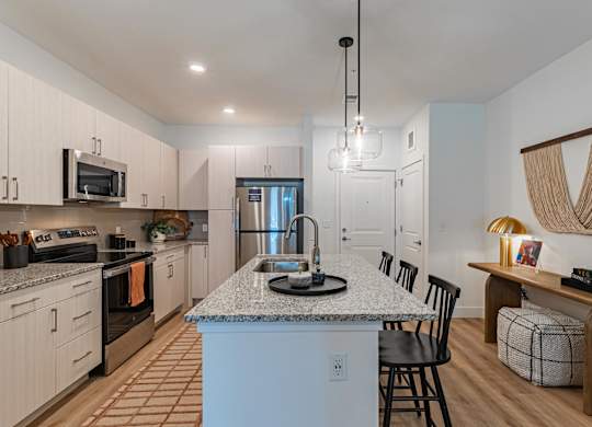 A kitchen with a granite countertop and a dining area with a bench.