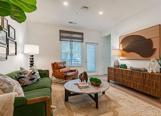 A furnished living room with a sofa and chair at Firestone Junction apartments for rent in Northern Colorado.
