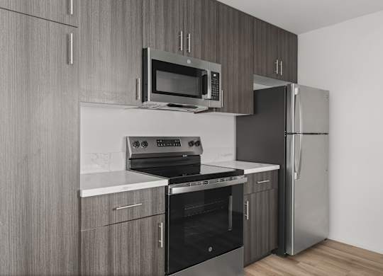 A modern kitchen with updated cabinetry and countertops with stainless steel appliances.
