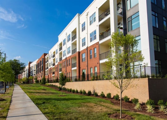 an exterior view of an apartment building with a sidewalk