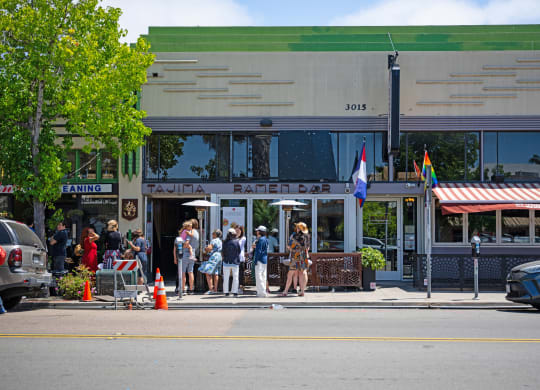 people standing outside of a restaurant on a city street