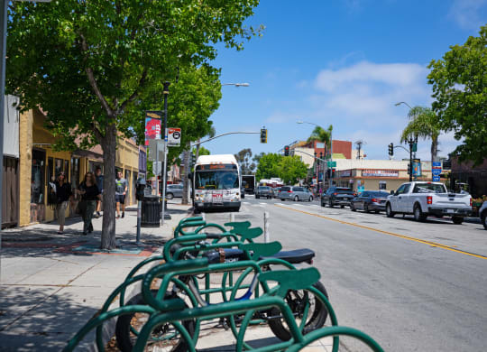 a bus driving down a city street with parked bikes on a sidewalk
