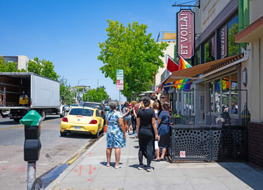 people standing outside of a restaurant on a city street