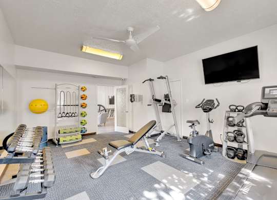 A well equipped gym with a variety of exercise equipment.