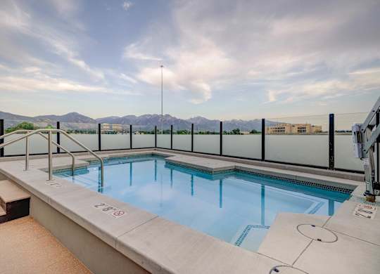 A small indoor pool with a glass railing and a mountain view.
