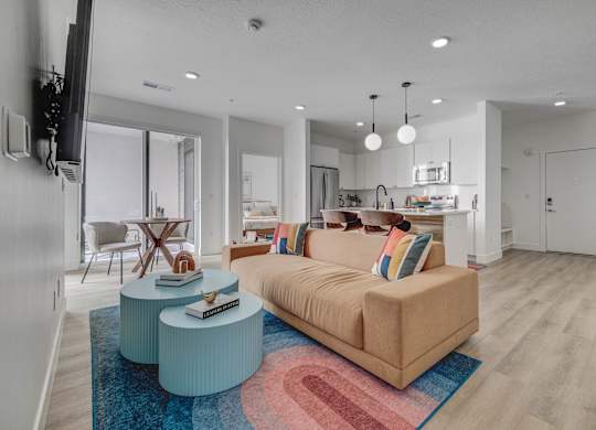A living room with a couch, a coffee table, and a television.