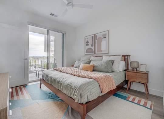 A bedroom with a bed, nightstand, and a ceiling fan.