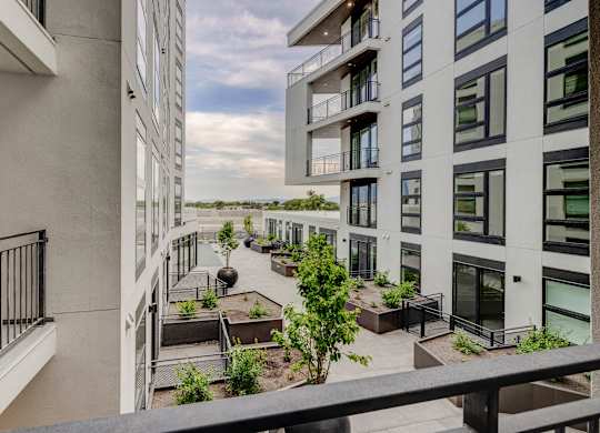 A balcony with a view of a building and a tree.