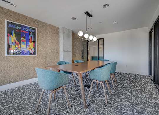 A conference room with a wooden table and blue chairs.