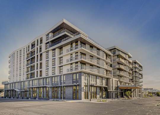 A large, modern building with a flat roof and multiple balconies.