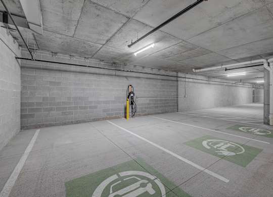 A parking garage with a bicycle parked in the corner.