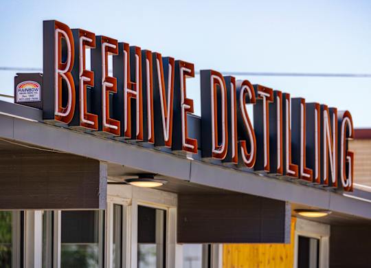 A sign for BeeHive Distilling is displayed on a building.