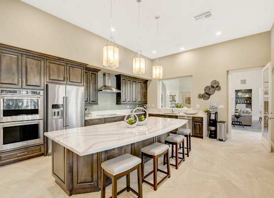 Clubhouse kitchen with a center island and bar stools.