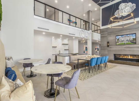 a lobby with tables and chairs and a fireplace