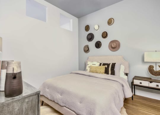 a bedroom with a bed and several hats on the wall