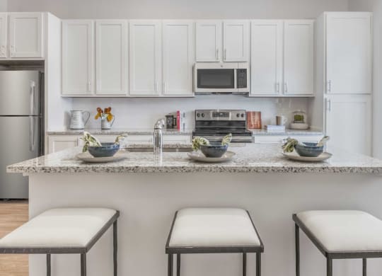 a kitchen with a marble counter top with three stools