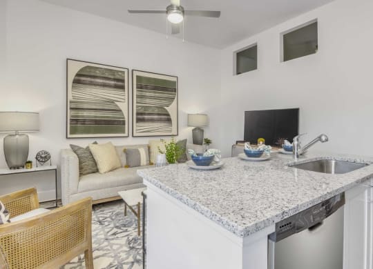 a kitchen with a counter top next to a living room