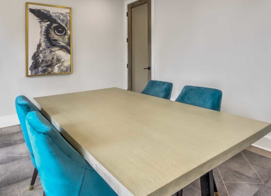 a dining room table with three blue chairs