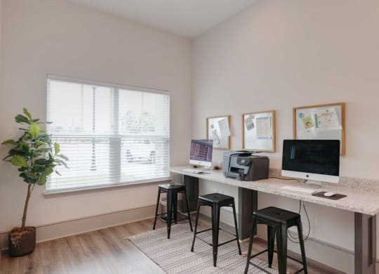 a home office with a computer and a desk with stools