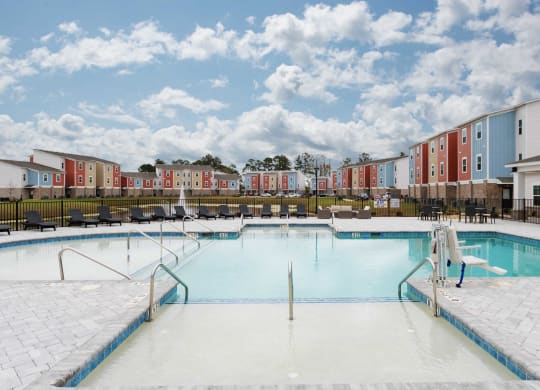 a swimming pool with an apartment building in the background