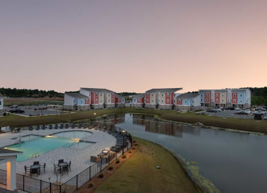 a building with a pool and a lake at dusk