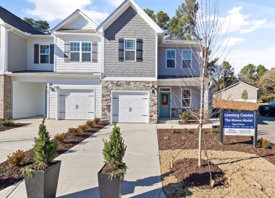 a home for sale with a sign in front of it
