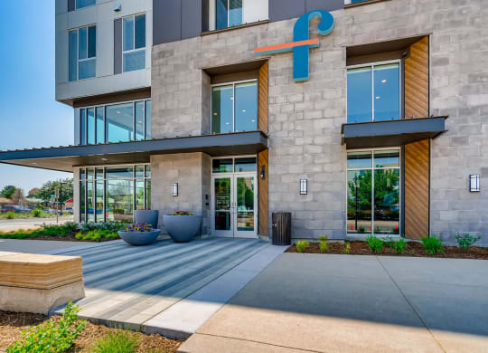 the facade of a building with large glass doors and a sidewalk in front of it