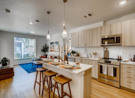 an open kitchen and living room with an island and stools