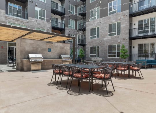 an outdoor patio with tables and chairs at an apartment building