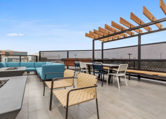 a rooftop patio with tables and chairs and a blue couch