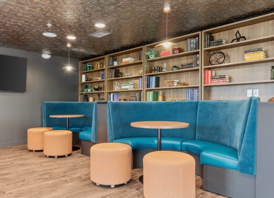 a lobby with blue chairs and tables and a tv