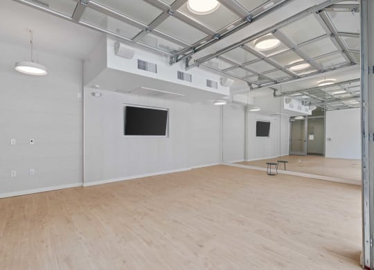 a large room with a wooden floor and a tv on the wall