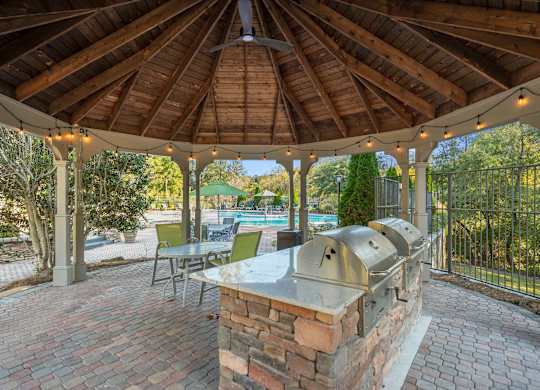 a patio with a barbecue grill and a pool